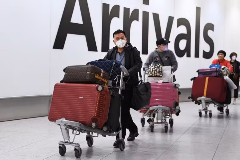 Người dân đeo khẩu trang tại sân bay ở London. Ảnh: EPA-EFE