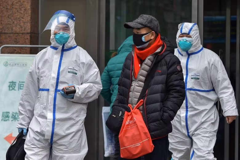 Nhân viên y tế cùng người dân đi bộ bên ngoài một bệnh viện ở Vũ Hán. Ảnh: AFP