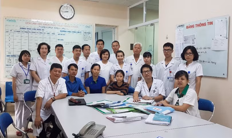 Anh Nhi (giữa) cùng bố mẹ và tập thể các y bác sĩ khoa Phẫu thuật nhiễm khuẩn trước ngày nhập học