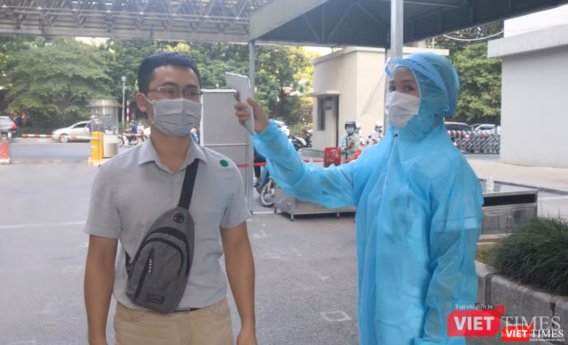 Nhân viên y tế đo nhiệt độ của người dân (Ảnh - Minh Thuý)