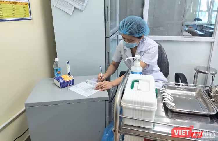 Nhân viên y tế ghi chú sau khi tiêm phòng cho trẻ (Ảnh: Minh Thuý) Nhân viên y tế ghi chú sau khi tiêm phòng cho trẻ (Ảnh: Minh Thuý)