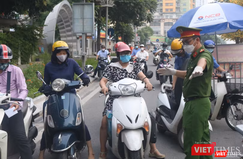 Cán bộ kiểm tra giấy tờ, ra hiệu cho phương tiện di chuyển tránh ùn tắc (Ảnh - Minh Thuý)
