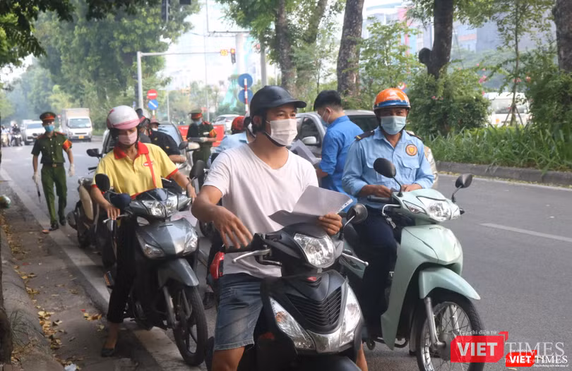 Người dân xếp hàng chờ kiểm tra giấy tờ (Ảnh - Minh Thuý)