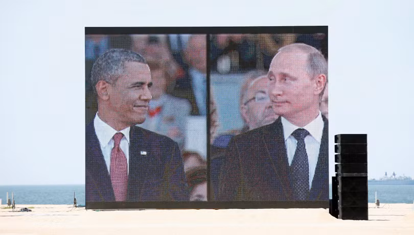 Một màn hình lớn có ảnh hai ông Obama và Putin tại Sword Beach khi họ tới lễ kỷ niệm quốc tế ngày đổ bộ D-Day tại Ouistreha ngày 6.6.2014.