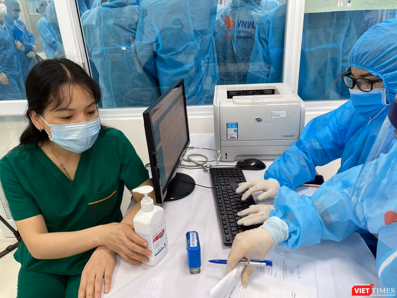 Nhân viên y tế kiểm tra hồ sơ, chuẩn bị tiêm vacicne phòng COVID-19 (Ảnh - Tuấn Dũng) 