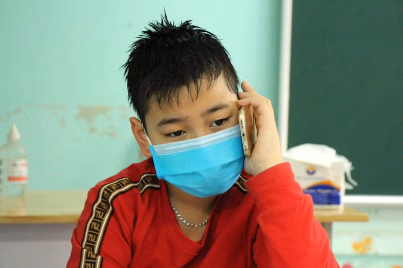 Em Hoàng (học sinh lớp 4D, Trường tiểu học Lai Cách) nghẹn ngào nghe điện thoại mà người thân gọi đến (Ảnh : BYT) Em Hoàng (học sinh lớp 4D, Trường tiểu học Lai Cách) nghẹn ngào nghe điện thoại mà người thân gọi đến (Ảnh : BYT)