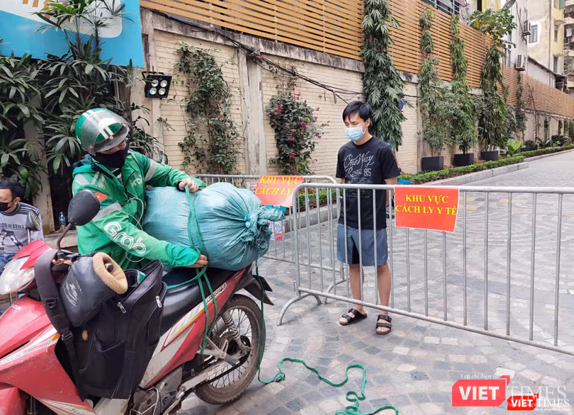 Người dân đứng sau rào chắn chờ nhận đồ (Ảnh - Minh Thuý)
