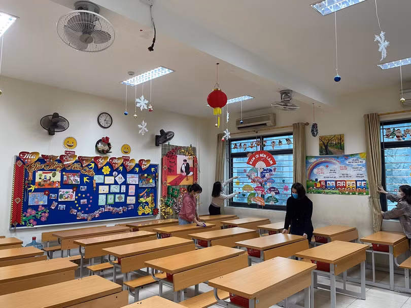 Giáo viên vệ sinh lớp học chuẩn bị đón học sinh đi học trở lại (Ảnh - ML)