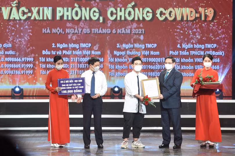 Thủ tướng Chính phủ Phạm Minh Chính trao chứng nhận, cảm ơn em Lê Đức Hiếu (15 tuổi), học sinh Trường Phạm Hồng Thái, Ba Đình, Hà Nội ủng hộ Quỹ vaccine phòng, chống dịch Covid-19.