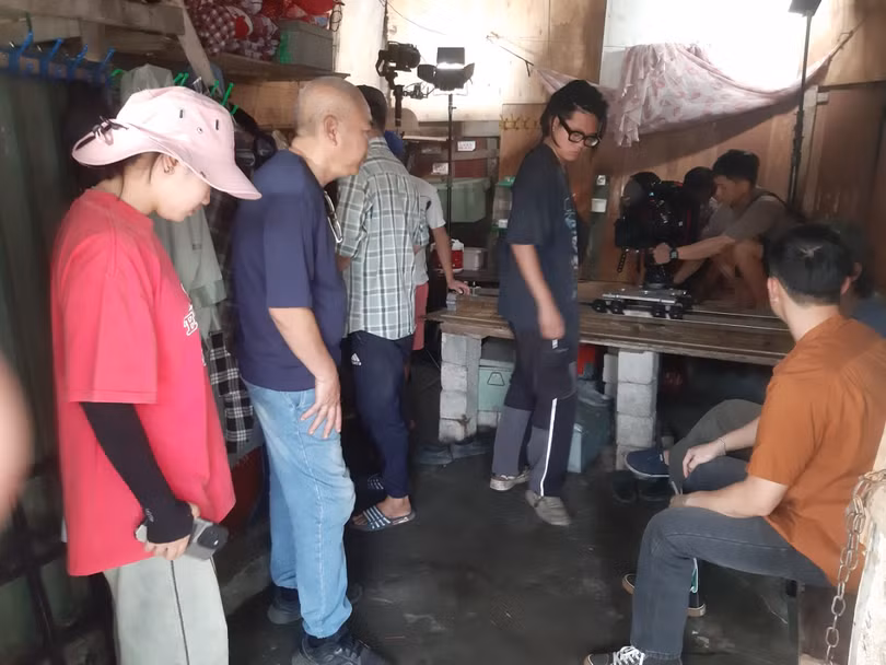 Đạo diễn Nguyễn Danh Dũng (người mặc áo xanh) đang hướng dẫn một cảnh quay